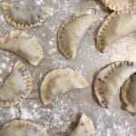 Pierogi leżące obok siebie na stolnicy