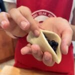Ręce lepiące pierogi z jagodami
